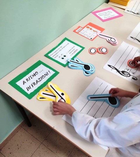 Bambini compongono ritmi con grandi note di carta