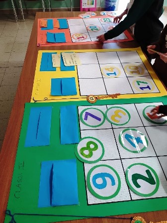 Bambini che dispongono numeri su dei grandi quadrati di cartoncino. Bambini che dispongono numeri su dei grandi quadrati di cartoncino.