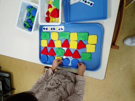 Bambina dispone forme geometriche costruite con la pasta di sale Bambina dispone forme geometriche costruite con la pasta di sale