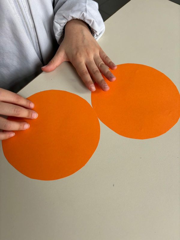 Mani di bambina su cerchi di carta.