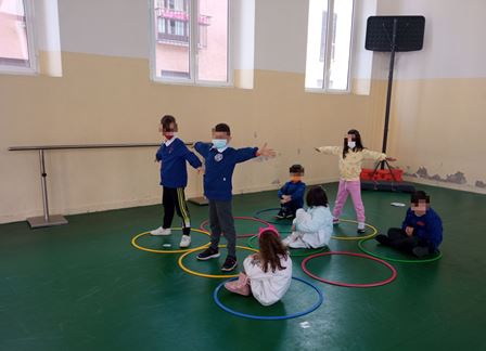 Bambini giocano in palestra con i cerchi Bambini giocano in palestra con i cerchi