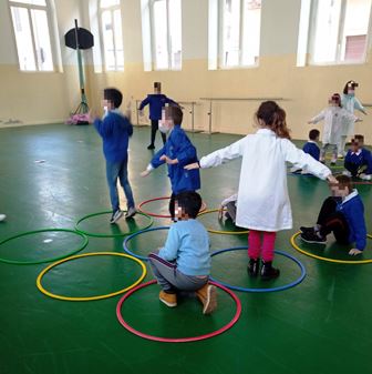Bambini in palestra giocano con i cerchi. Bambini in palestra giocano con i cerchi.